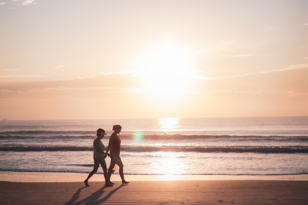 couple walking on beach at sunset