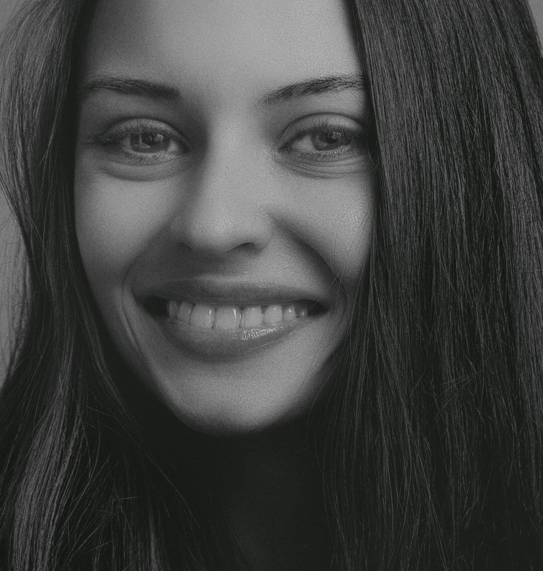Studio portrait of a young Latin American woman with dark hair smiling confidently