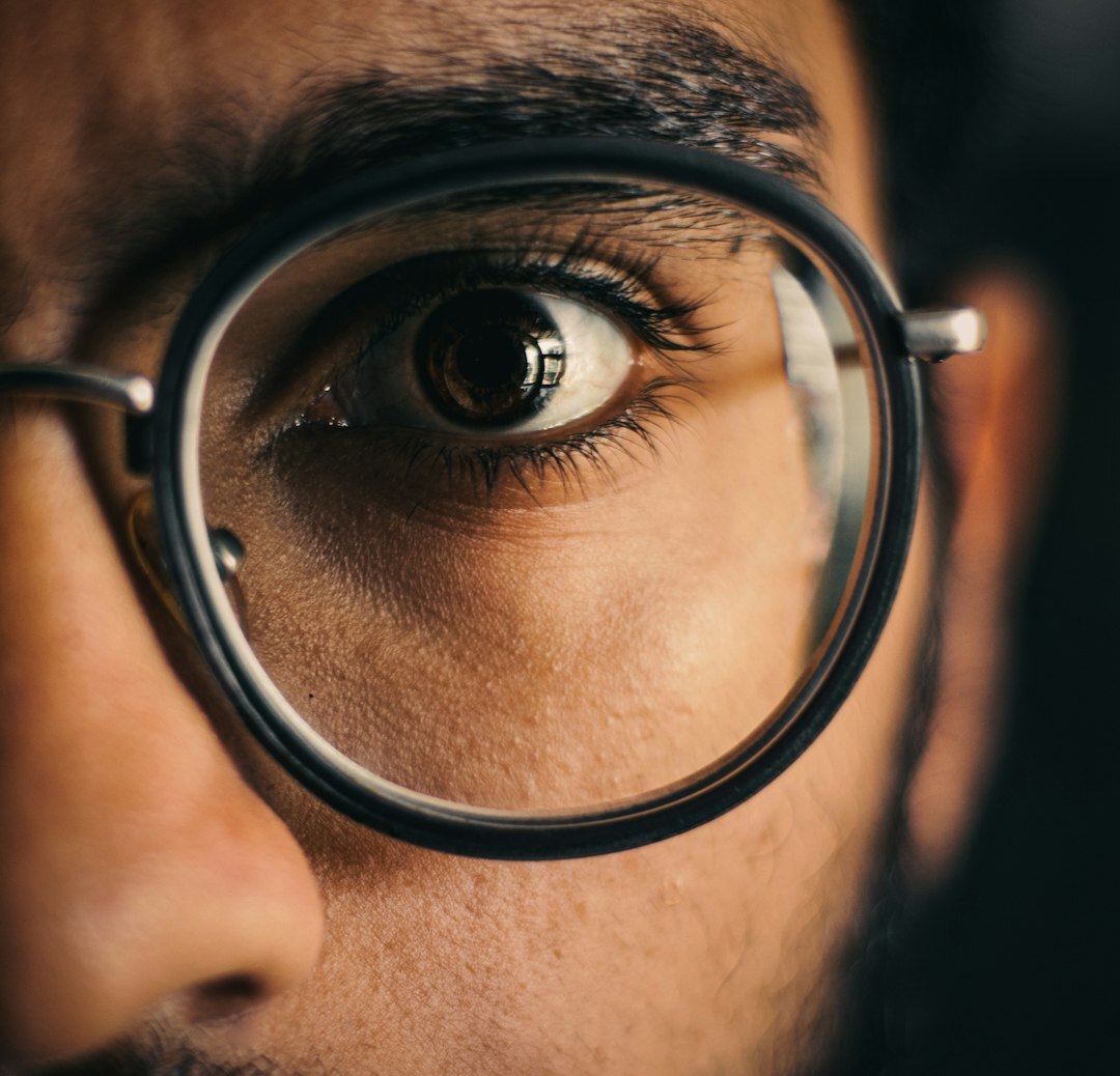 Studio portrait of a Latin American man with glasses and a beard