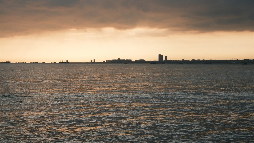 Coastal skyline at sunset with warm golden light over the water